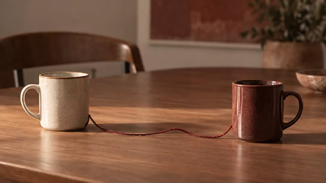 Dos tazas separadas unidas por un hilo sobre una mesa de trabajo